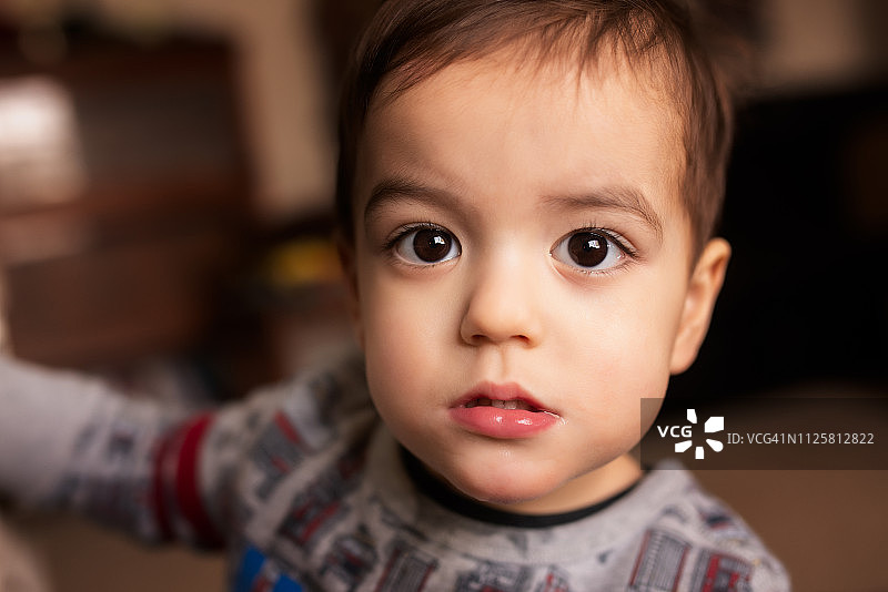 发烧生病的严肃棕发男童画像图片素材