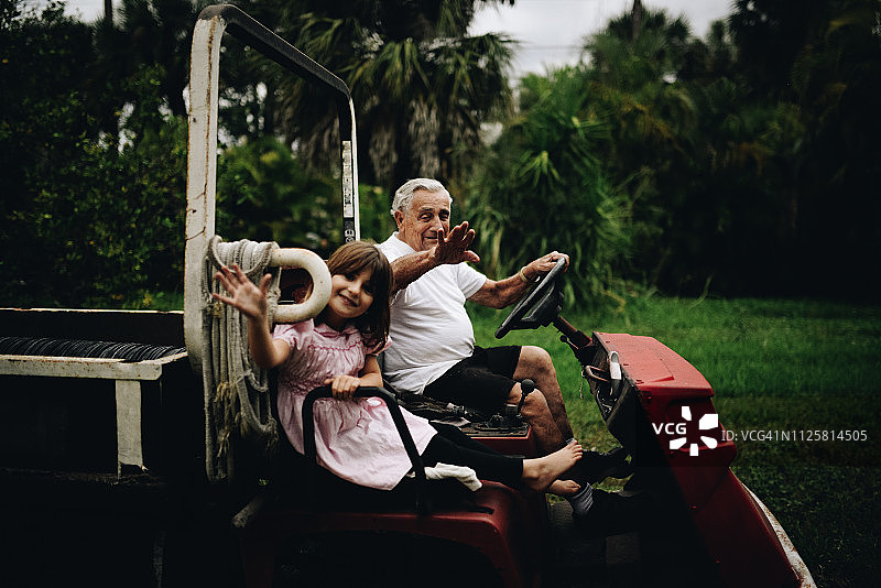 农场院子里，小女孩和曾祖父在手推车上图片素材