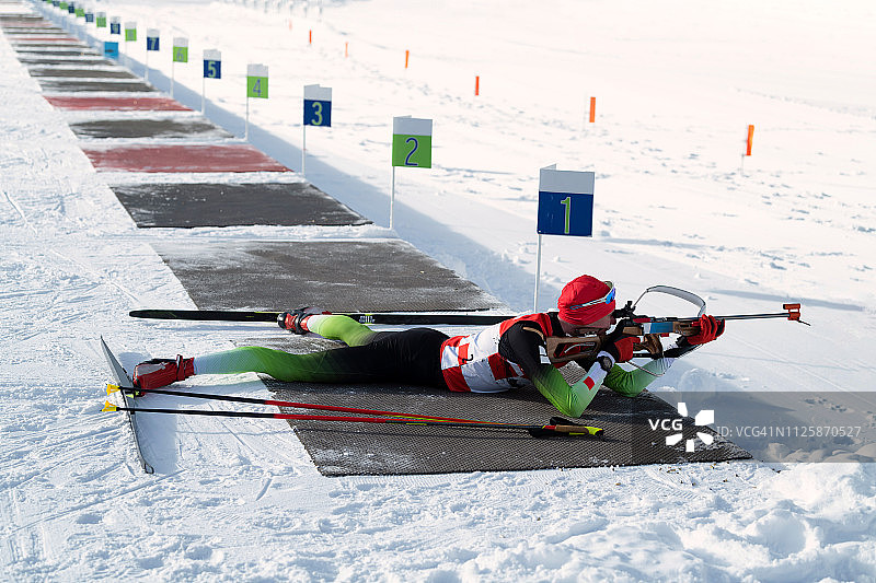 青年男子冬季两项选手卧姿射击训练侧视图图片素材