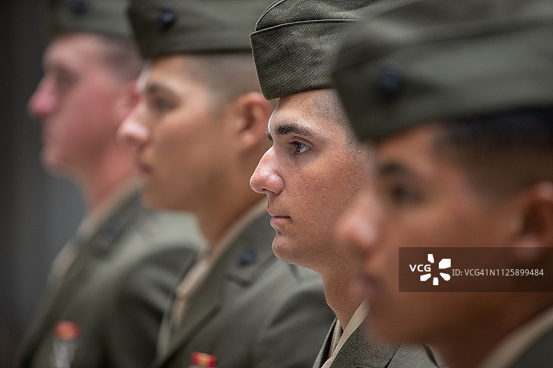穿着后备军官训练团制服的四个年轻男人一字排开，立正站好图片素材