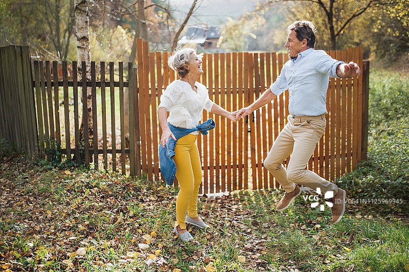 一对快乐的年长夫妇在户外跳跃图片素材