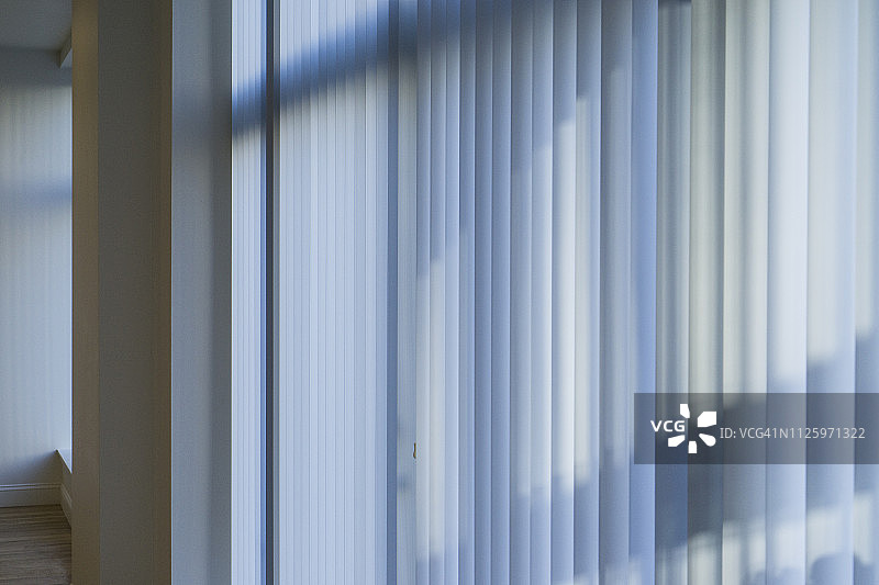 光线穿过空荡荡的公寓里紧闭的百叶窗图片素材