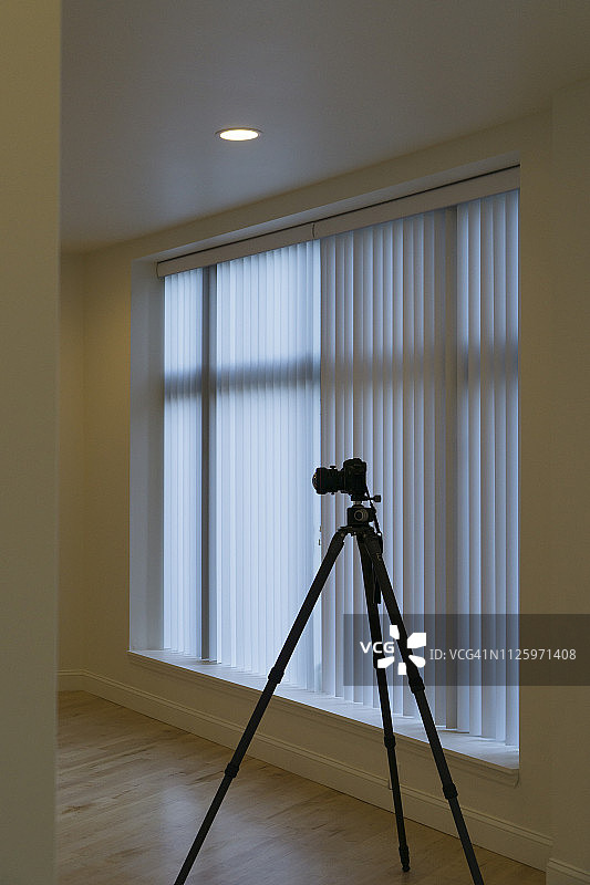 空公寓里三脚架上的摄影师相机图片素材