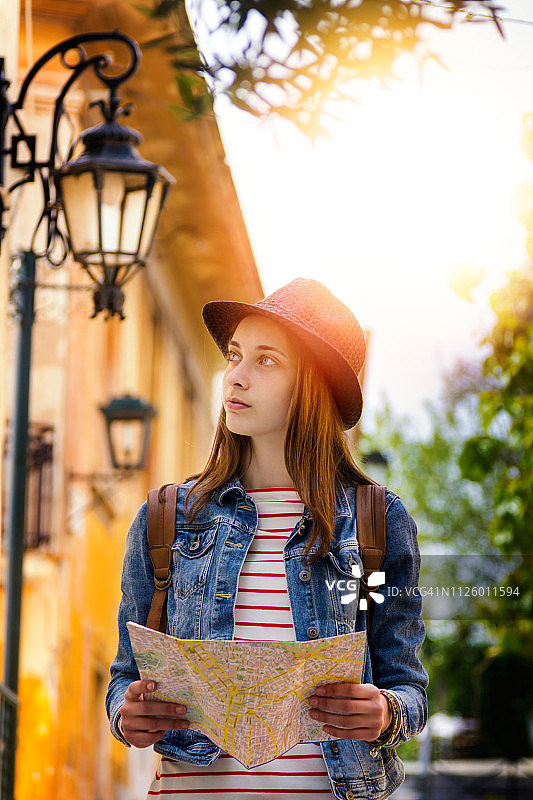 具有时尚外观的女游客在夏季出国旅行时在地图上搜索方向图片素材