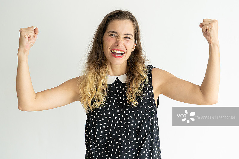 挥舞拳头庆祝成功的兴奋年轻女人图片素材