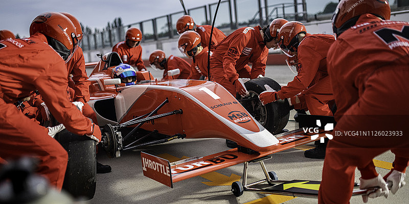 技师在方程式赛车维修站更换轮胎图片素材