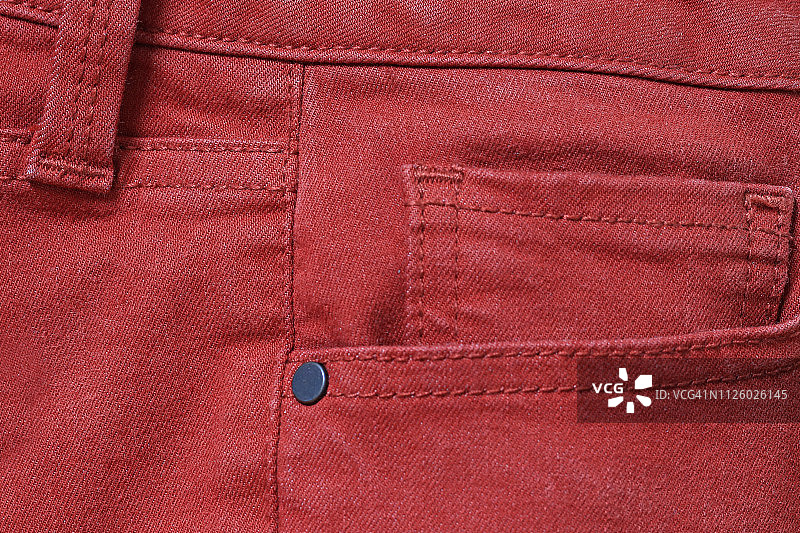 红色牛仔裤的侧视图，展示口袋和腰带环图片素材