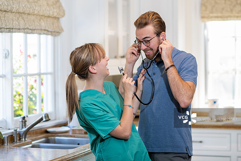 医疗专业人员和丈夫在厨房享用咖啡图片素材