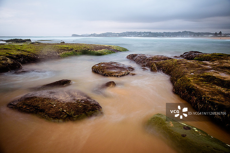 海滩岩石上波浪的长曝光照片图片素材