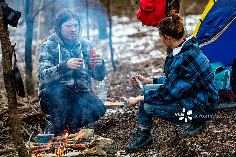 中年夫妇在冬季露营时准备晚餐图片素材