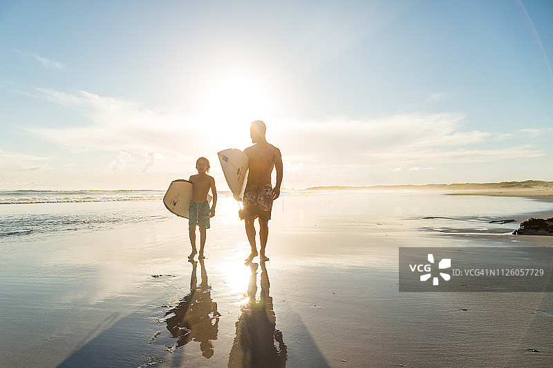 父子在沙滩上一起冲浪图片素材