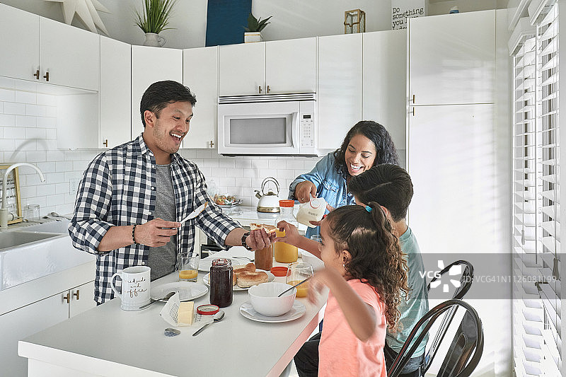 快乐的父母为孩子们提供食物和饮料图片素材