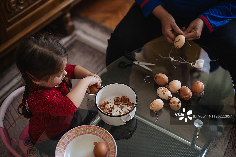 四岁女孩和奶奶一起装饰复活节彩蛋俯视图图片素材