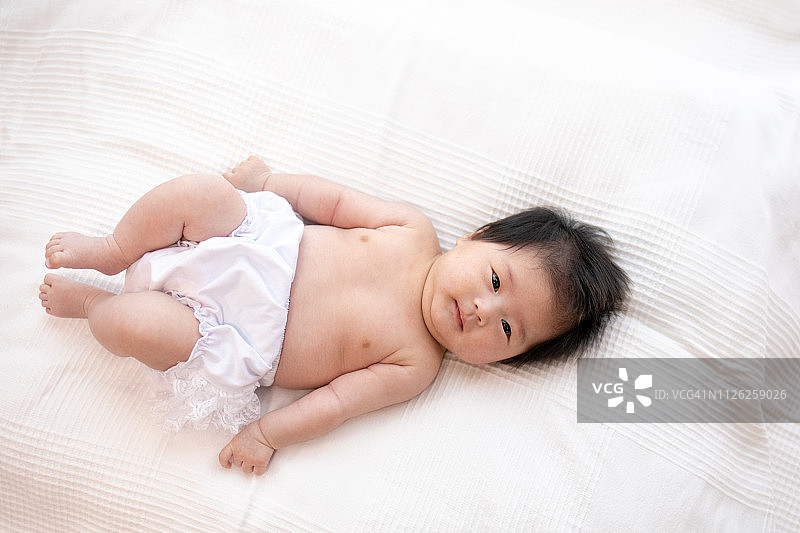 仰卧在客厅里的女婴图片素材