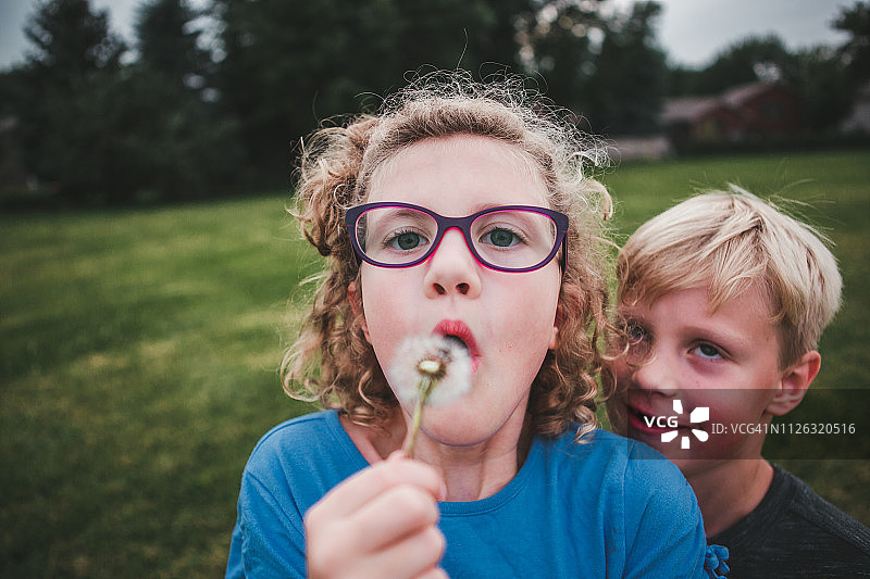 女孩吹蒲公英，傻男孩图片素材