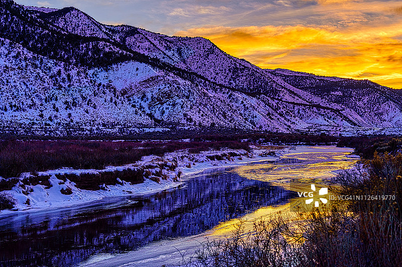 冬季河流中倒映着鲜艳的日落图片素材