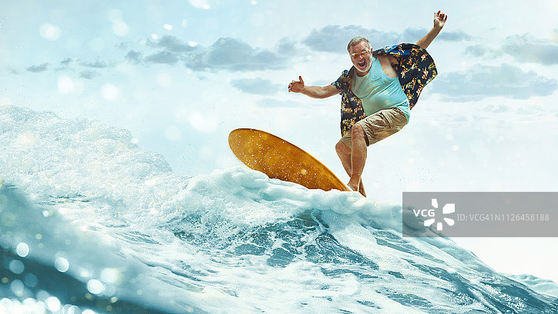 一位年长的男人在冲浪板上图片素材