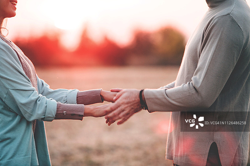 情侣在日落时手牵着手图片素材