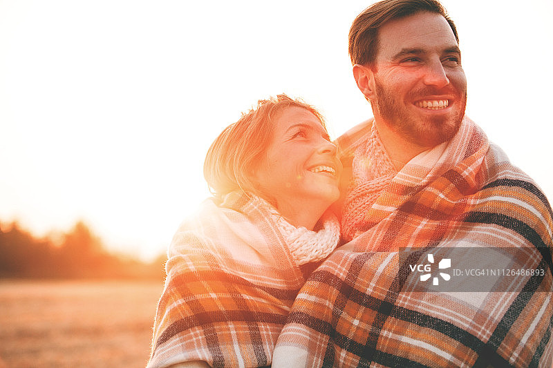 户外裹着毯子的恩爱夫妻图片素材