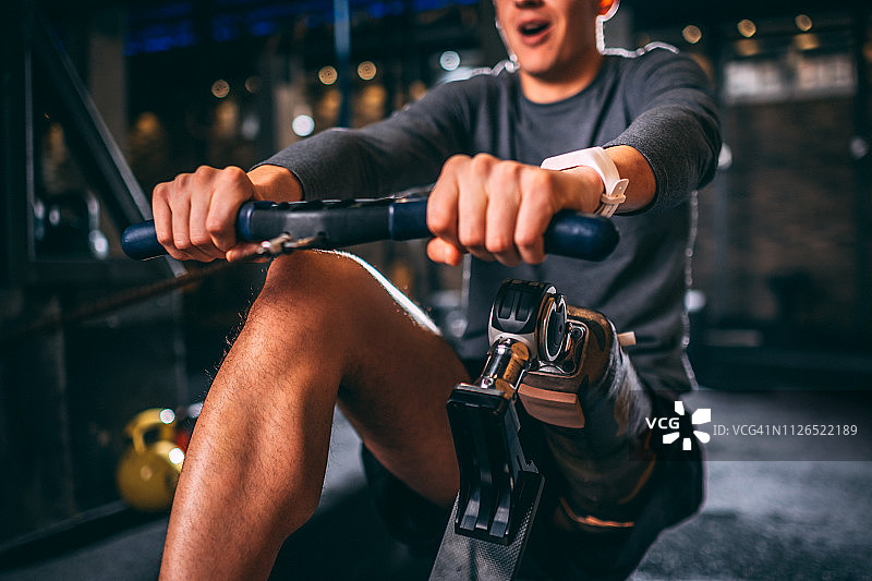 在健身房做拉伸运动的装有假肢的年轻运动员图片素材