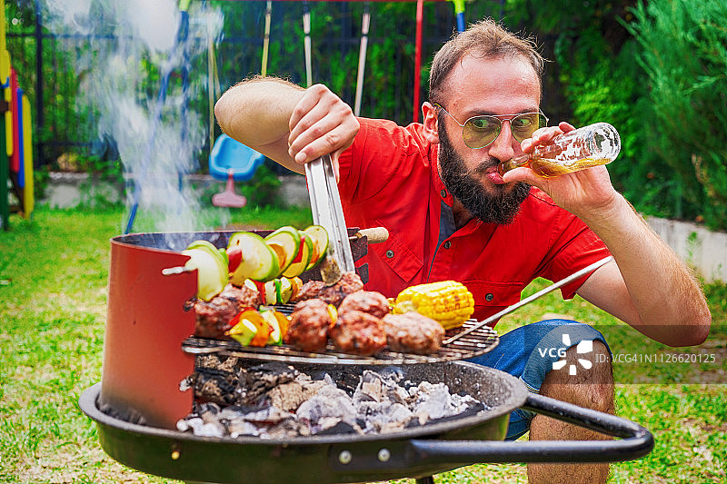 男人准备烧烤并喝啤酒图片素材
