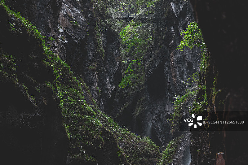 横跨峡谷或裂缝的桥。岩石在前景和背景。图片素材