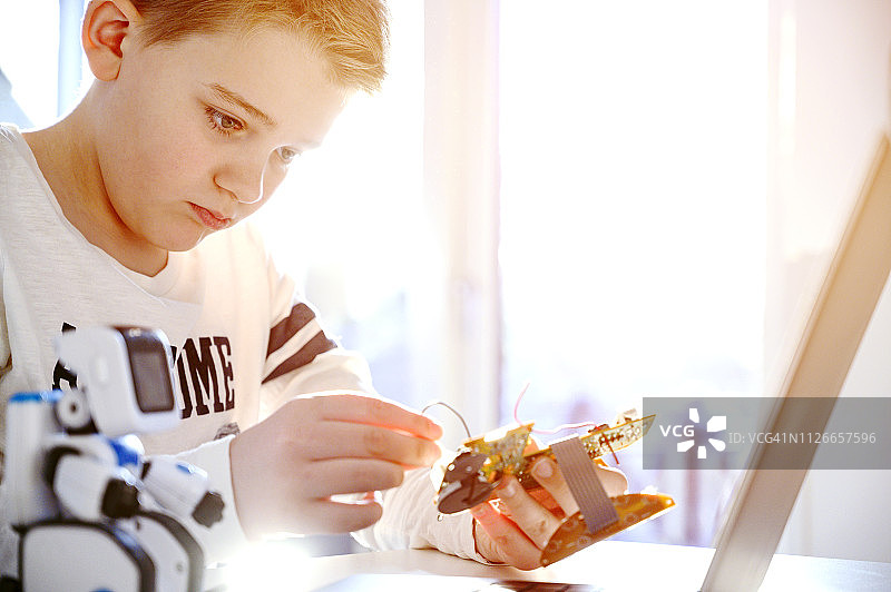 儿童专注于科学项目，试图使电路板工作图片素材