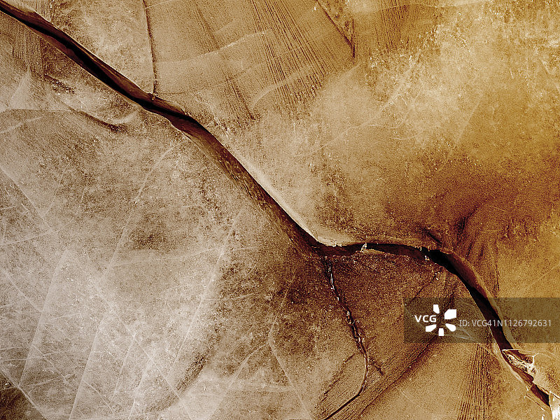 柔和棕色背景上的裂冰纹理图片素材