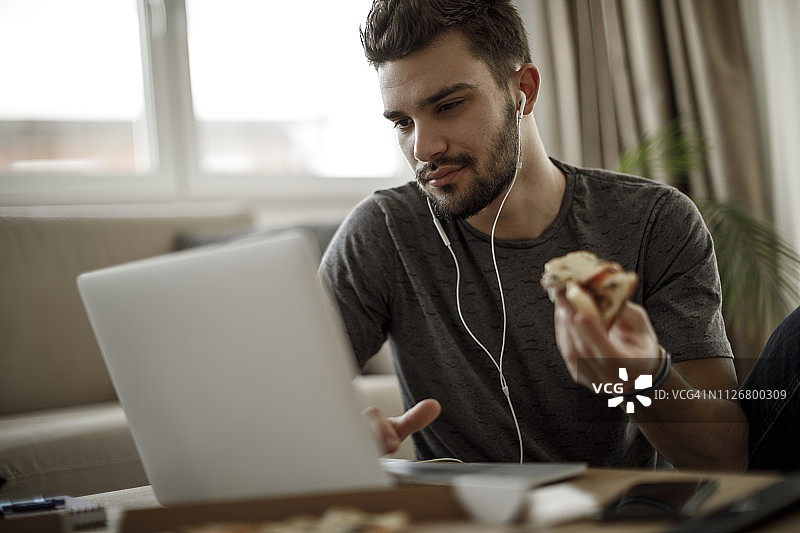 在家使用笔记本电脑的年轻男人图片素材