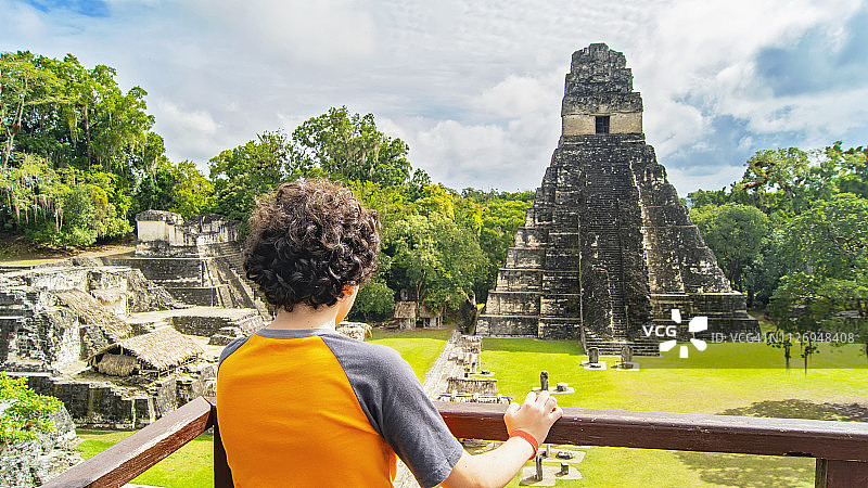 男孩欣赏危地马拉的玛雅美洲虎大金字塔图片素材