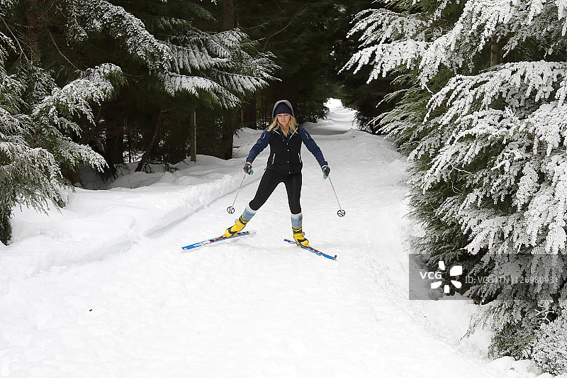 年轻女子在森林中滑雪图片素材