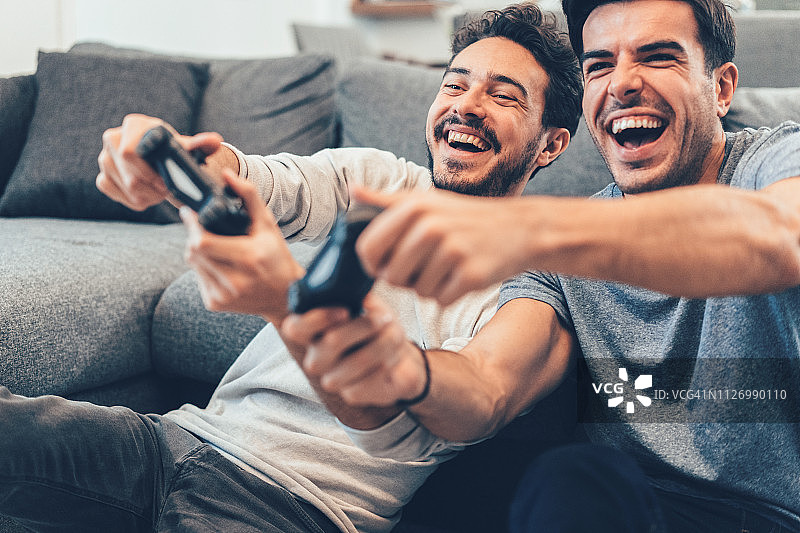 兴奋的朋友们玩电子游戏图片素材