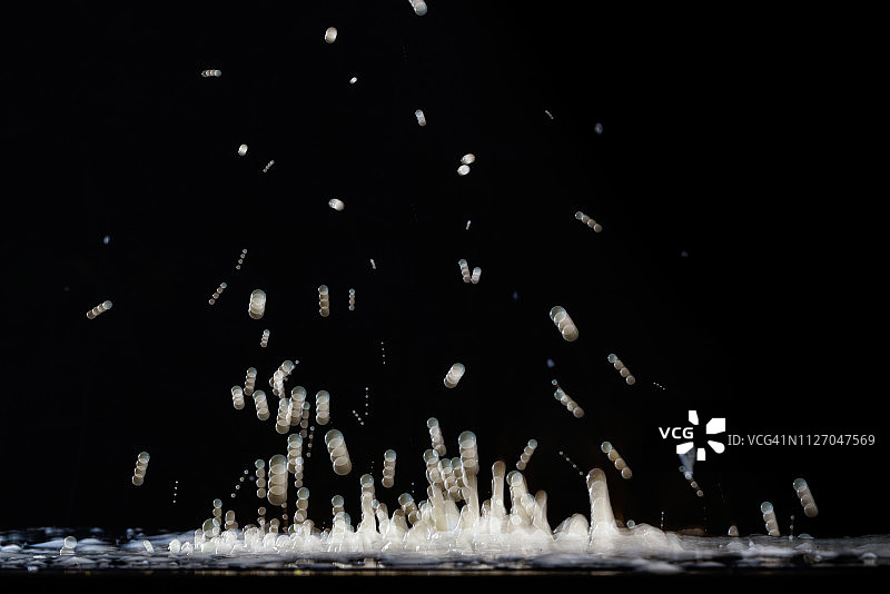 频闪灯光下悬浮的白色染料液滴图片素材