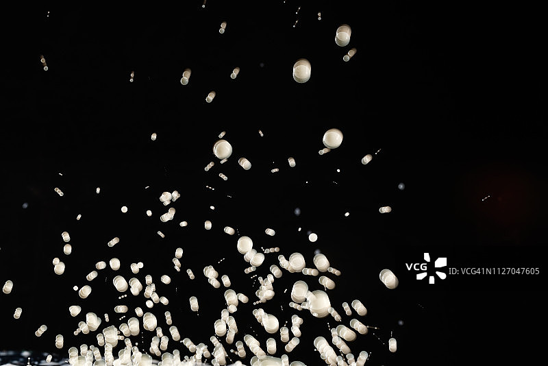频闪灯光下悬浮的白色染料液滴图片素材