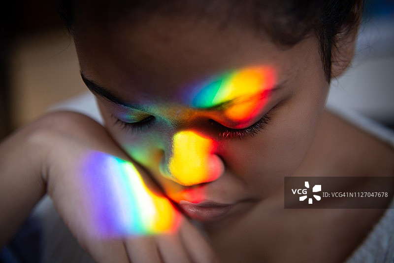 彩虹光反射在脸上图片素材