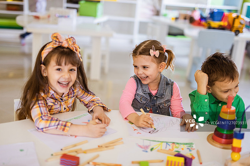 在幼儿园写生的微笑小女孩和她的朋友们图片素材