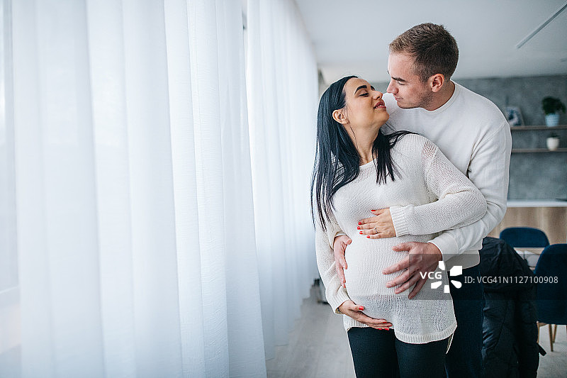 父母抚摸着孕妇的肚子图片素材