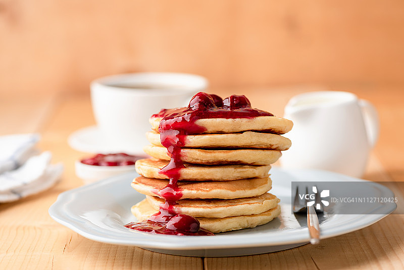 木桌上配樱桃酱的煎饼早餐图片素材