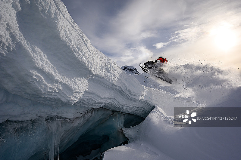 运动员在雪地摩托上做跳跃运动图片素材