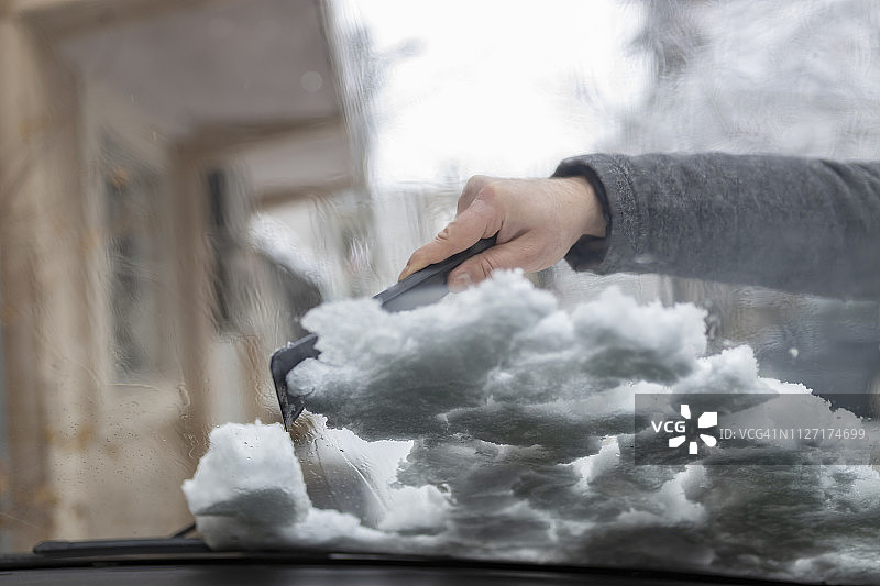 男人清除汽车上的积雪图片素材