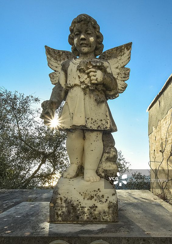 欧洲墓地里的死亡天使与穿过他手的邪恶阳光图片素材