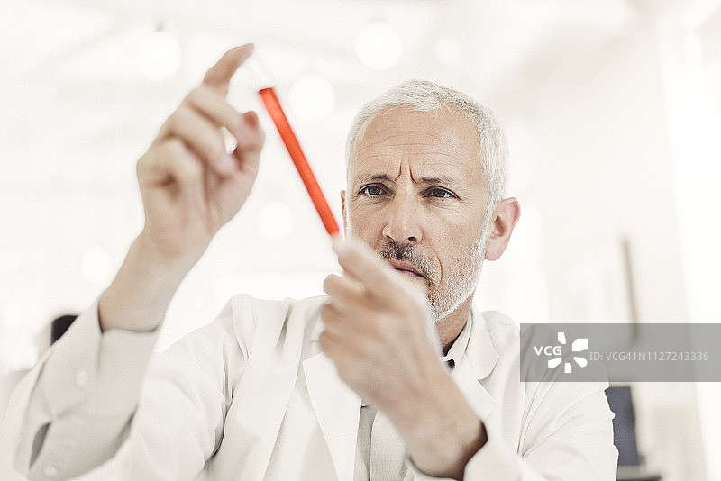 医生在实验室检查试管中的蓝色样本图片素材