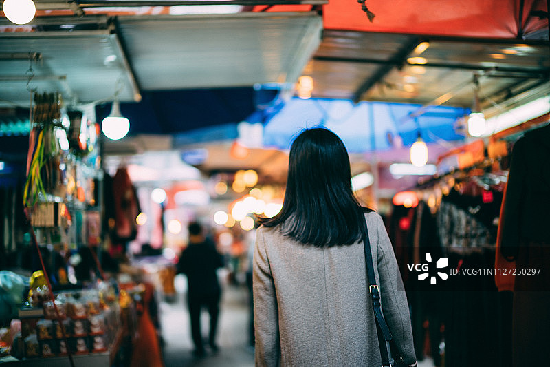 年轻女子在香港当地市场摊位逛街图片素材