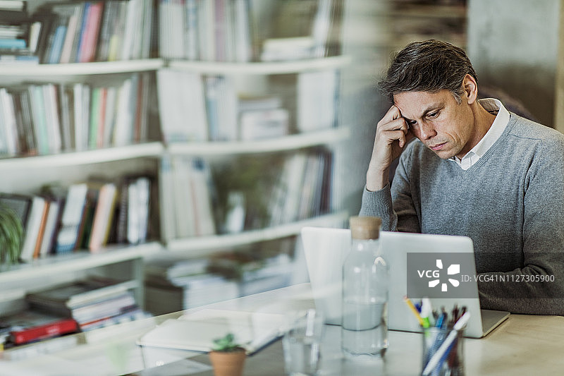 中年商人居家办公阅读电脑上的问题邮件图片素材
