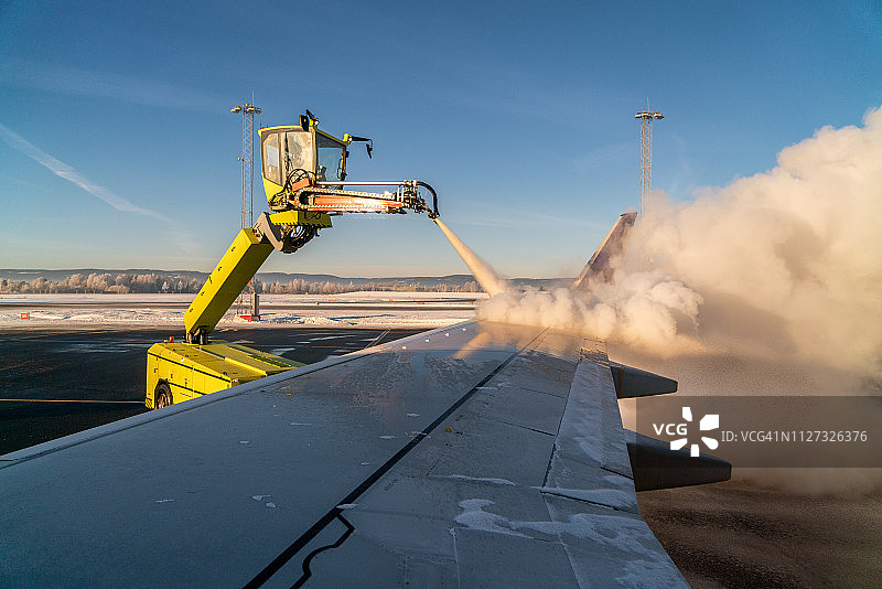 从飞机舷窗看到的飞机机翼除冰过程图片素材