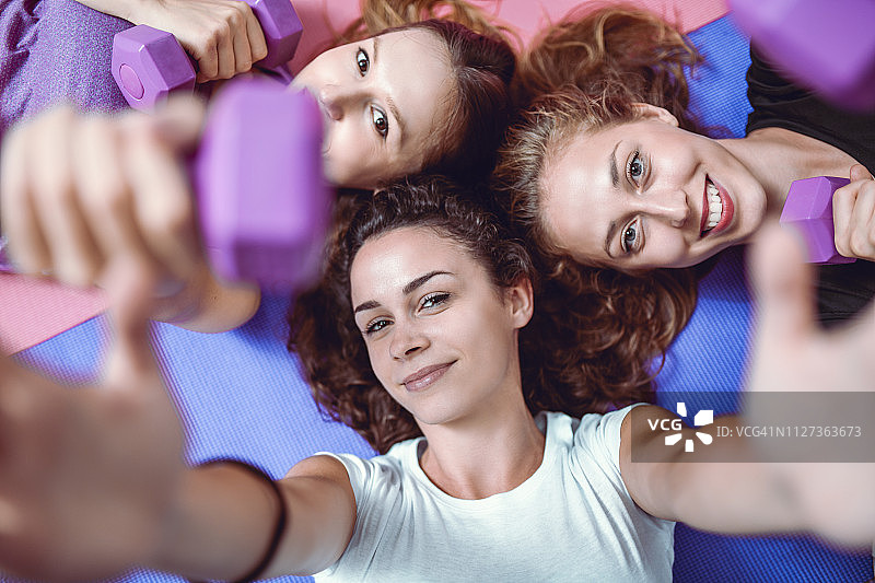 微笑的女性朋友在健身房自拍图片素材