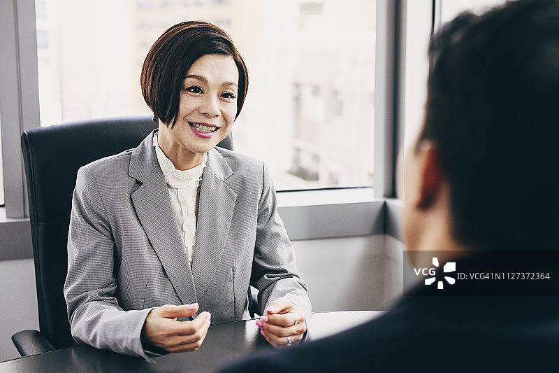 女商人微笑地与客户洽谈图片素材