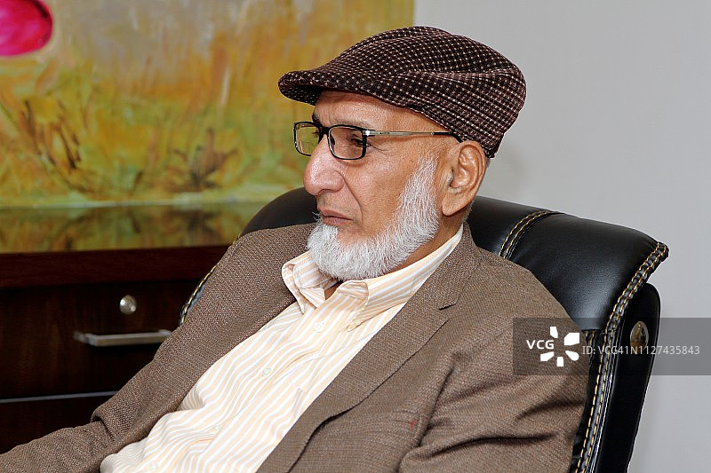 一位坐在办公椅上的年长男人图片素材