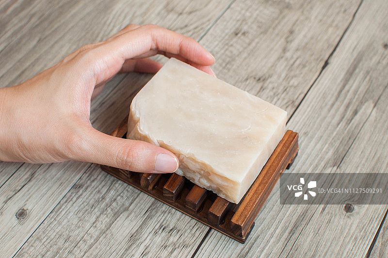 女性手持白色有机肥皂特写图片素材