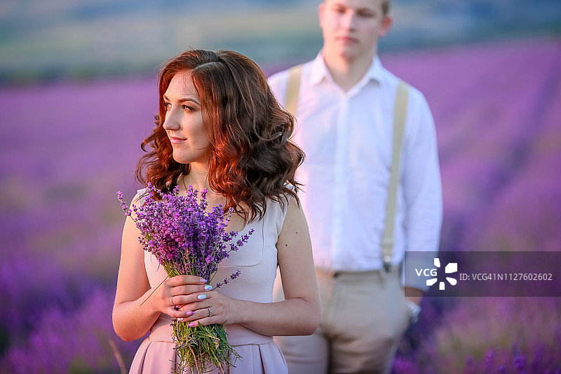 在薰衣草田日落时分相爱的年轻情侣肖像图片素材